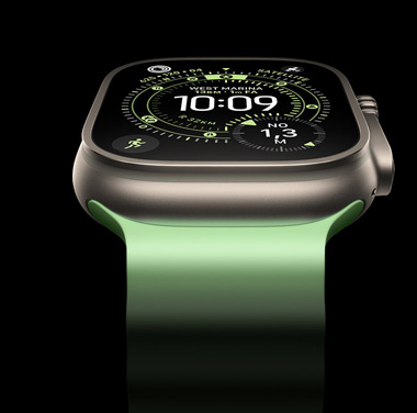 Primo piano di un Apple Watch Ultra 3 con cassa in titanio naturale su sfondo nero. Il quadrante mostra l’ora e altre informazioni dinamiche.