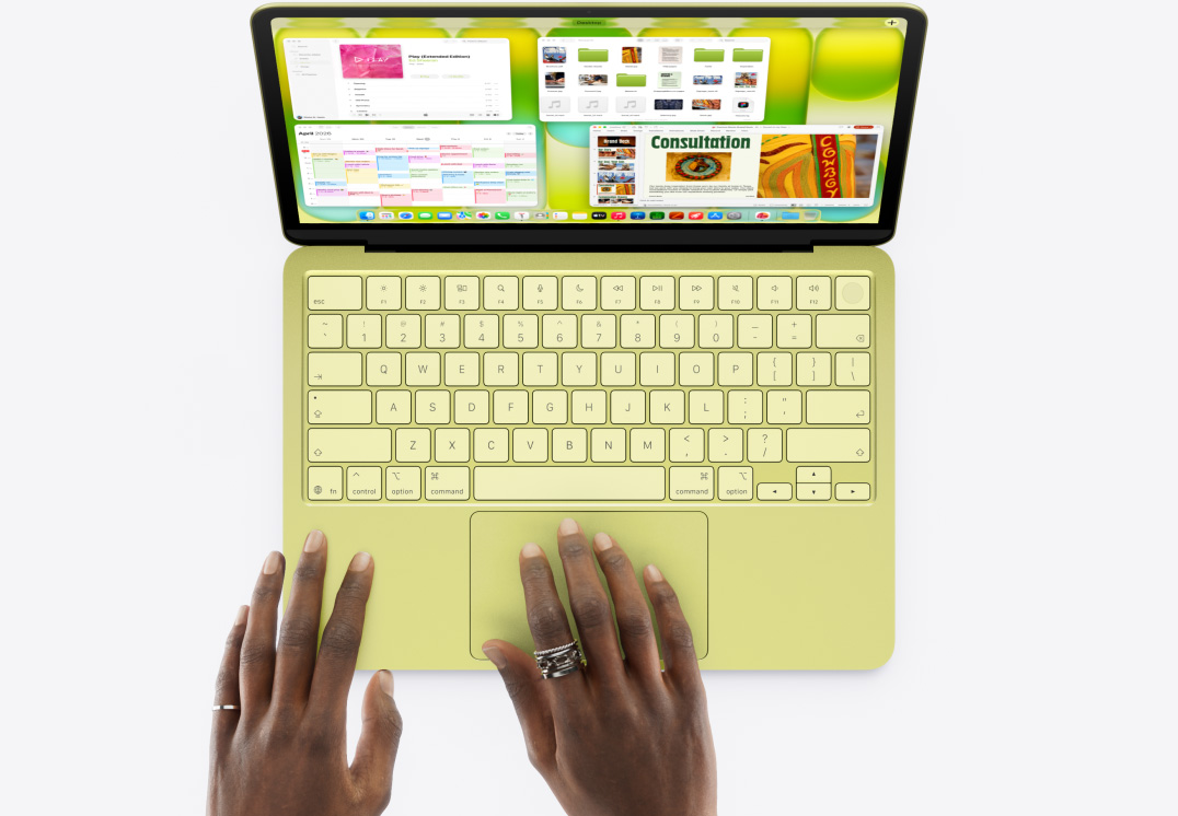 橘黃色 MacBook&nbsp;Neo，有隻手放在觸控板上，螢幕畫面中包含音樂和日曆等 app