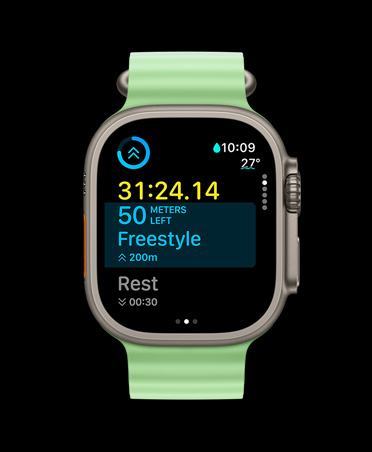 Apple Watch Ultra 3 z kopertą z tytanu w kolorze naturalnym, w aplikacji Trening widać kartę treningu własnego oraz widok Następne, zegarek ma pasek Ocean w kolorze neonowej zieleni