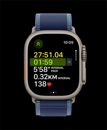 Apple Watch Ultra 3 z kopertą z tytanu w kolorze naturalnym, widać zaawansowane wskaźniki treningu Bieg w plenerze, zegarek ma opaskę Trail w kolorze niebieskim/jasnoniebieskim