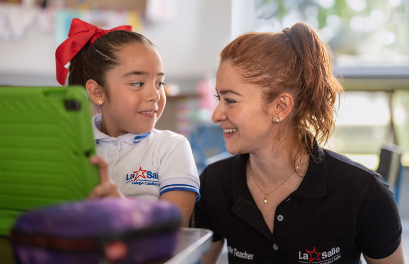 Eleane Ruth Guzmán Padilla unterhält sich mit einer Schülerin im Klassenzimmer des Colegio Cristóbal Colón.