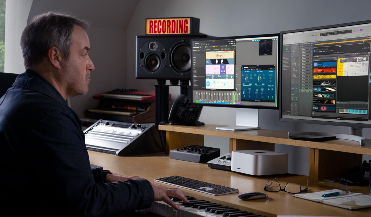 Ein Musiker verwendet ein Piano, um Audiomixes mit einem Mac Studio und einem Studio Display zu erstellen