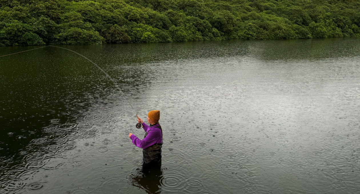 Foto einer Frau beim Fliegenfischen in einem See, das Pixelmator Pro Tool entfernt ein unerwünschtes Objekt im Hintergrund, das gelb hervorgehoben wird